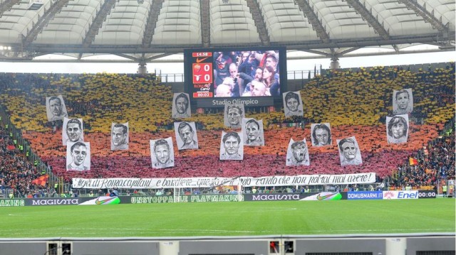 La coreografia della Curva Sud con Giorgio Carpi insieme ad altre bandiere. Fonte: As Roma
